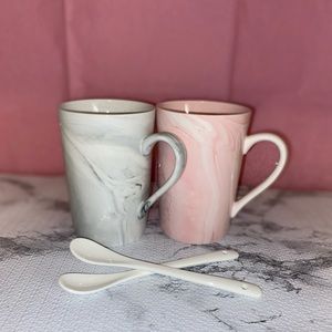 Two marble mugs with two glass spoons